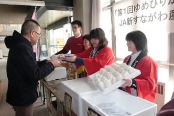 新砂川農協職員が市民の方におにぎりを配っている様子