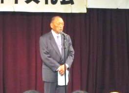 砂川市町内会連合会小関会長が壇上にて挨拶をしている様子