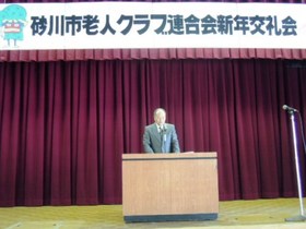 砂川市老人クラブ連合会鈴木会長が壇上にて挨拶をしている様子