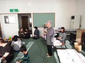 花園団地町内会の新年会会場を写した画像。女性(1名)がカラオケをしている様子