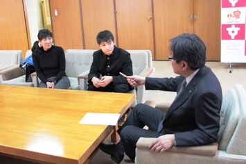 穴田玖舟君とお母さんがイスに座り市長と会話している様子