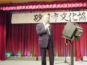 砂川市町内会連合会の小関会長がカラオケを披露している様子