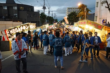 露店の中を神輿がやってきます