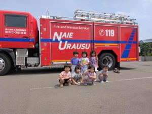 消防車の横で整列している園児