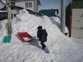 子どもが雪かきをする様子